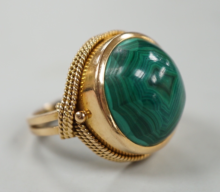 A yellow metal and cabochon malachite set dress ring, size F/G